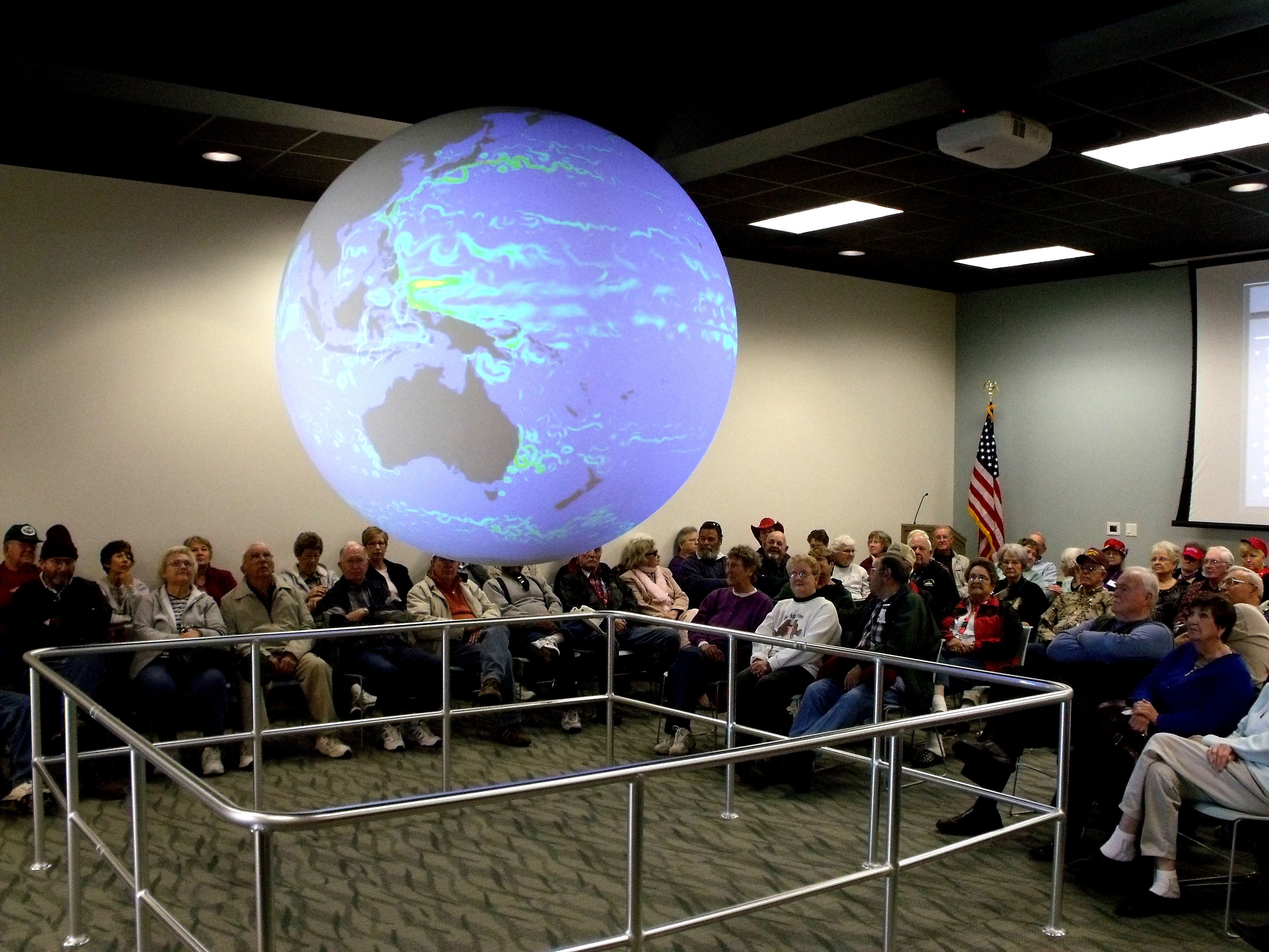 Visitors attend a Science on a Sphere presentation at the Bay Education Center