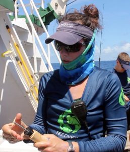 PhD student Lela Schlenker holds a device used to outfit captured mahi with data-collecting tags. (Provided by RECOVER)