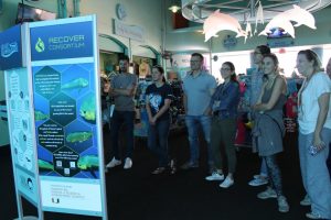 Members of the RECOVER research team visit the RECOVER exhibit at the Miami Seaquarium. The exhibit provides an overview of the RECOVER consortium, video displays highlighting their research, and a visualization of mahi mahi’s rapid growth in the early stages of its life. Photo Credit: RECOVER.
