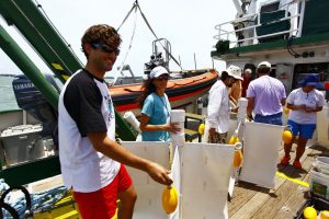 The CARTHE research team will deploy 300 custom-made drifters, as shown in this trial run, from the R/V Walton Smith. Left to Right: Dr. Guillaume Novelli, Dr. Angelique Haza, and Ph.D. student Matt Gough. Credit: Tamay Özgökmen (UM)