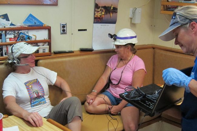 C-IMAGE_IMG_1727 From the RV Weatherbird II, Dr. Jacqueline Dixon (left, Dean USF College of Marine Sciences) and teacher Patty Smukall Skype with students about connections between the oil spill and underwater volcanoes. Dr. Teresa Greely assists with the session. (Photo credit: C-IMAGE)