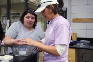 Dr. Tara Duffy helps participants use laboratory equipment to study marine larvae. Photo credit: (Jessica Hernandez)
