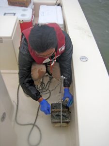 Hernando Bacosa with the DROPPS team collects sediment samples in Galveston Bay. (Photo provided by DROPPS)