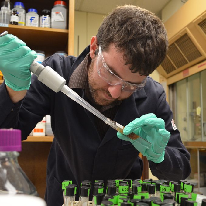 Andrew samples an oil-in-seawater emulsion, stabilized with polymer-coated iron oxide nanoparticles. (Photo provided by Worthen)