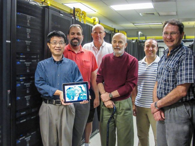 The NRL modeling team in their lab (from L-R) are Dr. Mozheng Wei, Dr. Charlie Barron, Dr. Ole Martin Smedstad, Mr. Paul Martin, Dr. Phil Muscarella, and Dr. Gregg Jacobs. The computer image that Wei is holding depicts temperature uncertainties predicted at the US Navy's Ensemble Prediction System over the Gulf of Mexico for July 17, 2012 during the CARTHE experiment. (Photo by Ms Jan Dastugue, NRL)