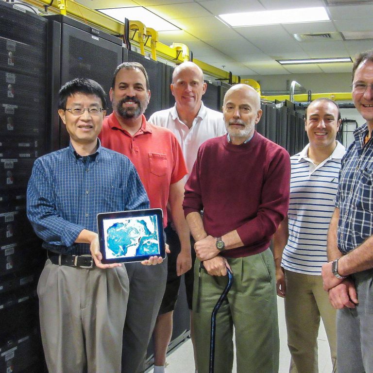 CARTHE_NRLmodelingteam_photo The NRL modeling team in their lab (from L-R) are Dr. Mozheng Wei, Dr. Charlie Barron, Dr. Ole Martin Smedstad, Mr. Paul Martin, Dr. Phil Muscarella, and Dr. Gregg Jacobs. The computer image that Wei is holding depicts temperature uncertainties predicted at the US Navy's Ensemble Prediction System over the Gulf of Mexico for July 17, 2012 during the CARTHE experiment. (Photo by Ms Jan Dastugue, NRL)