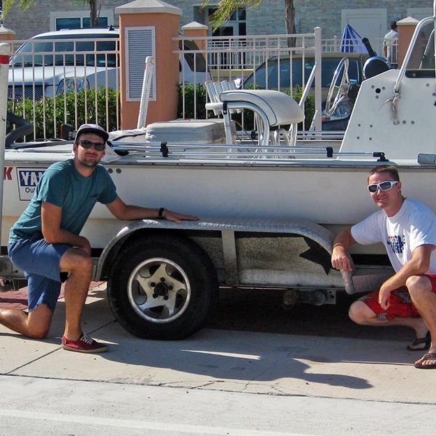 Dave Christiansen (left) and Garrett Kehoe (right) pose with their beloved but shambling boat trailer, which lost two of its four wheels during a data collection trip from Austin to Galveston Bay. (Photo credit: Matt Rayson)