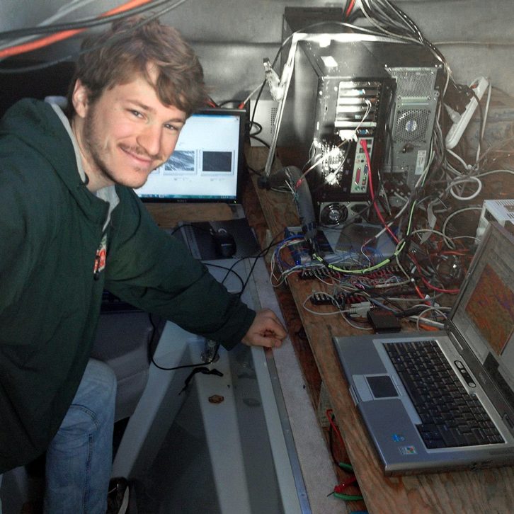 Nathan stands proudly in front of the data acquisitions system he set up inside the Surface Physics Experimental Catamaran (SPEC) during the 2013 Surfzone-Coastal Oil Pathways Experiment (SCOPE) in Destin, FL. (Photo credit: Tamay Özgökmen)