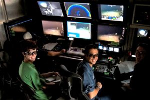 Rich Dannenberg (left), ROV pilot Toshi Mikagawa (center), and Samantha Berlet (right) wear 3D glasses to view live footage of coral beds deep beneath the Gulf. (Photo provided by Rich Dannenberg)