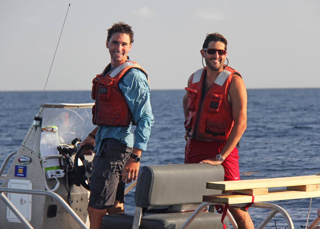 Conor_3_credit_David_Nadeau-HEADLINE Conor and UM researcher Guillaume Novelli (right) celebrate the end of a long day recovering and redeploying drifters. On this day, they tracked one hundred drifters, recovered their GPS data, and released them back into the water. (Photo credit: David Nadeau)