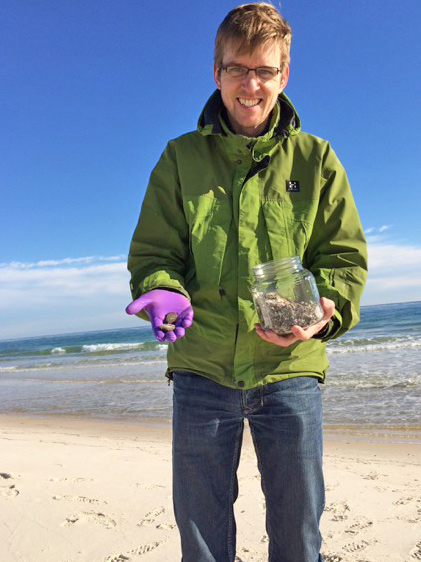 Christoph Aeppli collects samples of oil-soaked sand patties in Gulfshores, Alabama. (Photo credit: J. Suflita)