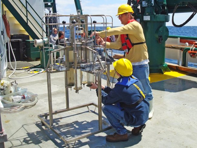 Florida State University graduate students Brian Wells and Brian DeSanti prepare to collect multicore samples on the deck of the RV Weatherbird II. (Photo by Jeff Chanton)