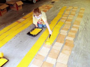 Alek paints his drift cards bright yellow using a non-toxic, biodegradable paint mixture. (Provided by Alek)