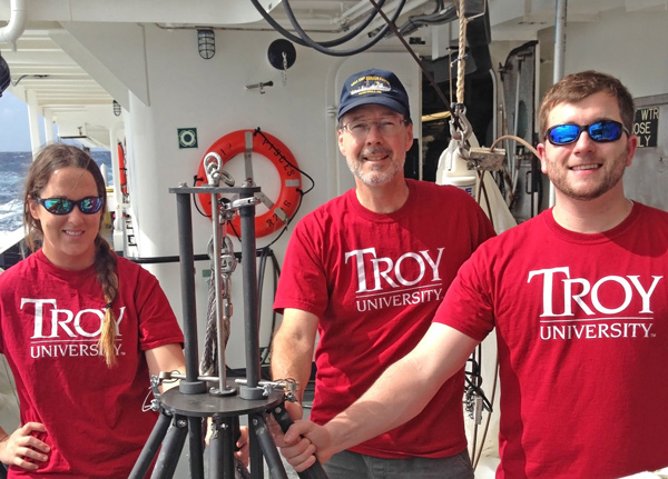 Ceil-TroyGroup_IMG_7438-FEATURED Ceil Martinec, Stephen Landers, and Craig Schimmer pose with the multicorer they use to retrieve sediment samples from the Gulf. (Photo courtesy of Stephen Landers)