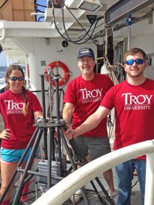 Ceil Martinec, Stephen Landers, and Craig Schimmer pose with the multicorer they use to retrieve sediment samples from the Gulf. (Photo courtesy of Stephen Landers)