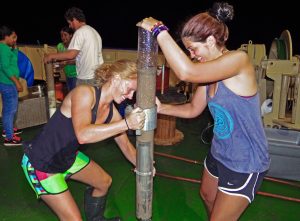 Undergraduate students Nichole Clark (left) and Rachael Kalin (right) transfer a sediment core aboard R/V Justo Sierra. (Provided by C-IMAGE)