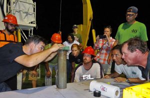 Researchers on the R/V Justo Sierra and crew look on as Patrick Schwing transfers a sample from the sediment corer. (Provided by C-IMAGE)