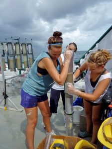 Eckerd College students transferring a multicore from a collection barrel to a working barrel aboard the R/V Weatherbird II, June 2011. (Photo provided by Gregg Brooks)