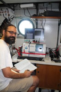 Adam takes notes in the R/V Point Sur’s lab while his FlowCam analyzes samples. (Photo by Alison Deary)