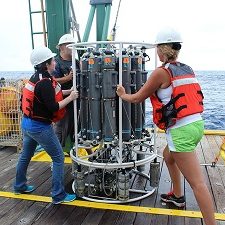 Senior research associate Jodi Brewster (left) and Ph.D. candidate Johna Rudzin (right) deploying a CTD with Nanson bottles off the University of Miami R/V F. G. Walton Smith, a ship in the University-National Oceanographic Laboratory System fleet. (Photo by Jodi Brewster).