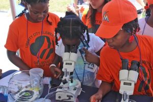 Miami Girl Scouts look at mahi-mahi embryos at an Ocean Kids outreach event. University of Miami students with the RECOVER consortium set up hands-on learning stations about the ocean. (Photo by RECOVER)