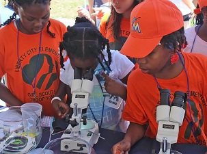 Miami Girl Scouts look at mahi-mahi embryos at an Ocean Kids outreach event. University of Miami students with the RECOVER consortium set up hands-on learning stations about the ocean. (Photo by RECOVER)