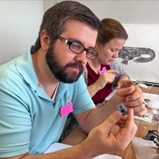 Christopher Hatten of Mildred Osborne Charter School contemplates the Arduino microcontroller board that he will later program to run his SeaGlide model. (Photo by Dinah Maygarden)