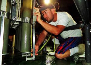 Patrick Schwing measures a sediment core extracted from the Gulf of Mexico seafloor. Photo Credit: Devon Firesinger 2015