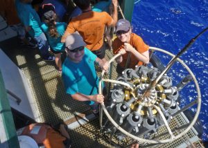 USF researchers Joel Ortega Ortíz and Sherryl Gilbert prepare a CTD (conductivity, temperature, and depth sensor) and water sampler for deployment off the north coast of Cuba. Photo courtesy of C-IMAGE