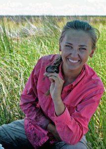Allison holds a Seaside Sparrow after a muddy day in the field. (Photo credit: Anna Perez-Umphrey)