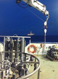 Researchers used CTD and Niskin bottle rosettes to collect dissolved organic carbon samples aboard the R/V Pelican. In the distance is a nearby drilling ship on the Gulf of Mexico. Photo credit: Brad Rosenheim