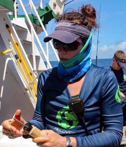 Lela Schlenker holds a device used to outfit captured mahi-mahi with data-collecting tags. (Provided by RECOVER)