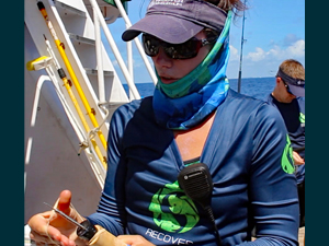 MahiMahiTagDevice_slider Lela Schlenker holds a device used to outfit captured mahi-mahi with data-collecting tags. (Provided by RECOVER)