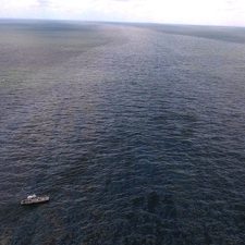 CARTHE-RFP5_AndroulidakisPhotoFieldExperiment_slider (Inset) Some of the study authors onboard a vessel used during their April 2017 field work (L-R Matthieu Le Hénaff, Oscar Garcia-Pineda, and Yannis Androulidakis). The larger picture shows oil moving in a current influenced by the Mississippi River plume. Photo by Oscar Garcia-Pineda.