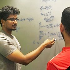 Explain_model_slider Aditya Aiyer (left) explains the Lagrangian dynamic Smagorinsky model that his team uses in their Large Eddy Simulations. (Provided by Aditya Aiyer)