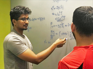 Aditya Aiyer (left) explains the Lagrangian dynamic Smagorinsky model that his team uses in their Large Eddy Simulations. (Provided by Aditya Aiyer)