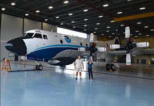 Luna Hiron and Josh Wadler of the Rosenstiel School of Marine and Atmospheric Science stand in front of the WP-3D Orion "Hurricane Hunters" aircraft at the NOAA Aircraft Operations Center facility in Lakeland, Florida. (Provided by Luna Hiron)