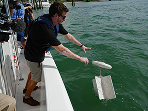 John Lodise releases a drifter during a BayDrift experiment near the Rosenstiel School campus. (Photo credit: Diana Udel)