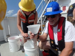 (L-R) Dr. Isabel C. Romero (College of Marine Science University of South Florida) and Dr. Jon Moore (Wilkes Honors College at Florida Atlantic University) collect samples from midwater trawling that used a 10-m2 MOCNESS net during DEEPEND Consortium cruises. Photo provided by Isabel Romero, courtesy of DEEPEND.
