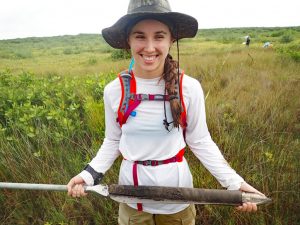 Ioana Bociu holds a salt marsh core while conducting research at the Florida Fish and Wildlife Research Institute. (Photo credit: Dr. Ryan Moyer)