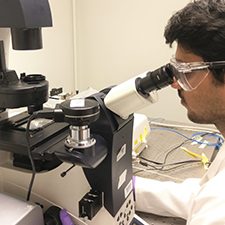 RFP 5 Conrad_slider Study co-author Narendra Dewangan, a graduate student in Chemical Engineering at the University of Houston, examines marine bacteria adhered to oil droplets using a confocal microscope. Credit: Diego Soetrisno (member of Conrad lab)