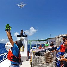 DroneRelease_slider Guillaume Novelli (L) releases a Phatom 4 pro drone from the RV Walton Smith while Cedric Guigand (R) operates the flight controls during the CARTHE SPLASH experiment. High-resolution cameras on the drone collected aerial observations of floating bamboo drift plates and fast-evolving fronts at 1 meter – 200 meters scales. Photo by Tamay Ozgokmen, University of Miami Rosenstiel School of Marine and Atmospheric Science.