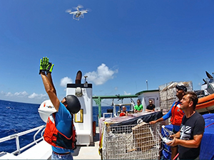 Guillaume Novelli (L) releases a Phatom 4 pro drone from the RV Walton Smith while Cedric Guigand (R) operates the flight controls during the CARTHE SPLASH experiment. High-resolution cameras on the drone collected aerial observations of floating bamboo drift plates and fast-evolving fronts at 1 meter – 200 meters scales. Photo by Tamay Ozgokmen, University of Miami Rosenstiel School of Marine and Atmospheric Science.
