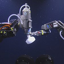 cam1_20150418135200_slider This image shows the gas bubble collection apparatus on the left and the remotely operated vehicle (ROV) sampling arm on the right. Cameras mounted on the ROV Hercules took this underwater photo. Credit: Ocean Exploration Trust, Inc.