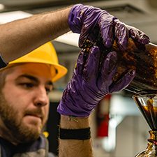 Master’s student Matthew Kurpiel, Coastal Carolina University, pours oil and seawater into a funnel that separates the fluids. (Used with permission from photographer Jason Gonzales iamjgvisuals.com.)