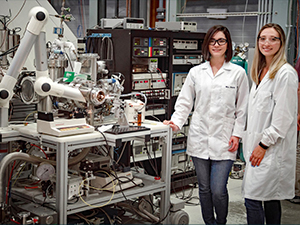9p4T-Martha-and-Sydney_slider Dr. Martha Chacon (left) and Ph.D. student Sydney Niles (right) stand next to the custom-built 9.4 Tesla FT-ICR MS used for molecular-level analysis of petroleum compounds. (Photo credit: Stephen Bilenky)