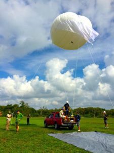 Members of the CARTHE research team test the helium-filled aerostat (Ship-Tethered Aerostat Remote Sensing System or STARRS) on land before experiments in the Gulf of Mexico. During the experiment, the aerostat took aerial pictures every 15 seconds of floating biodegradable bamboo plates used for studying how small-scale currents affect dispersion. Photo Credit: CARTHE