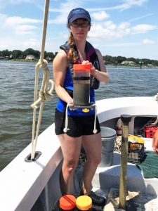 Virginia Institute of Marine Science Ph.D. student Danielle Tarpley holds a sediment core collected from the Lynnhaven River in Virginia. (Photo courtesy of Jessica Turner)