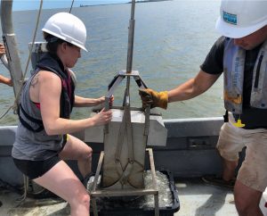 Virginia Institute of Marine Science Ph.D. student Danielle Tarpley (left) pulls in the GOMEX box corer while collecting sediment samples from the York River estuary in Virginia. (Photo courtesy of Grace Massey)