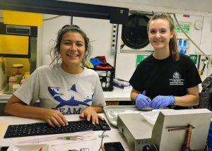 Nova Southeastern University master’s students Nina Pruzinsky (left) and Natalie Slayden (right) process samples collected from a deep-sea trawl during the DEEPEND Consortium DP06 research cruise. (Provided by DEEPEND)